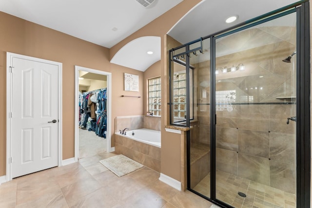 full bath featuring tile patterned floors, a garden tub, a stall shower, and a spacious closet