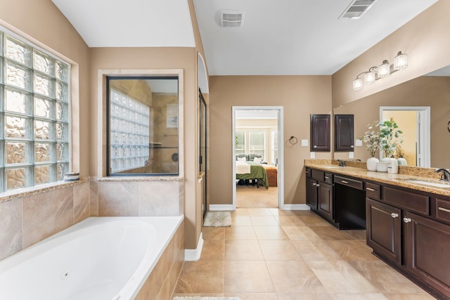 ensuite bathroom featuring a bath, visible vents, and a sink