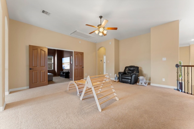 interior space featuring visible vents, carpet floors, arched walkways, baseboards, and attic access