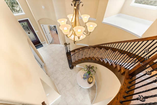 stairs featuring a towering ceiling and an inviting chandelier