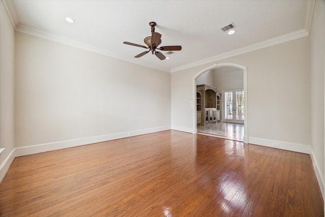 unfurnished room with ceiling fan, wood-type flooring, crown molding, and french doors