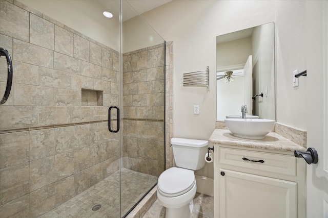 bathroom with walk in shower, vanity, toilet, and ceiling fan