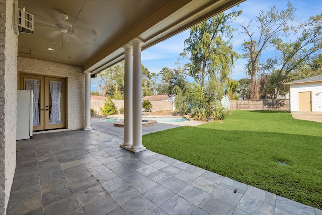 view of yard featuring ceiling fan, a fenced in pool, a patio, and french doors