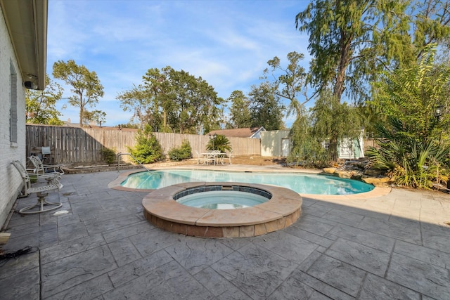 view of swimming pool featuring a patio area and an in ground hot tub