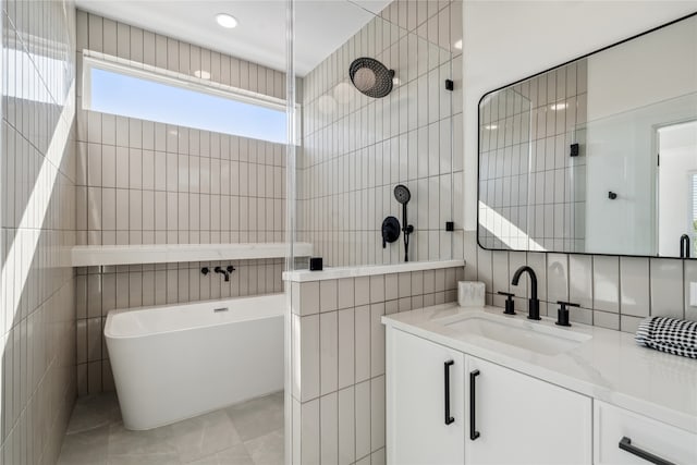 bathroom with vanity, tile patterned floors, tile walls, and independent shower and bath