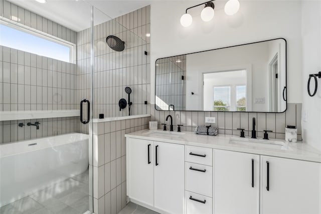 bathroom featuring plus walk in shower, tile patterned flooring, backsplash, vanity, and tile walls