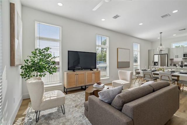 living room with ceiling fan and light hardwood / wood-style floors