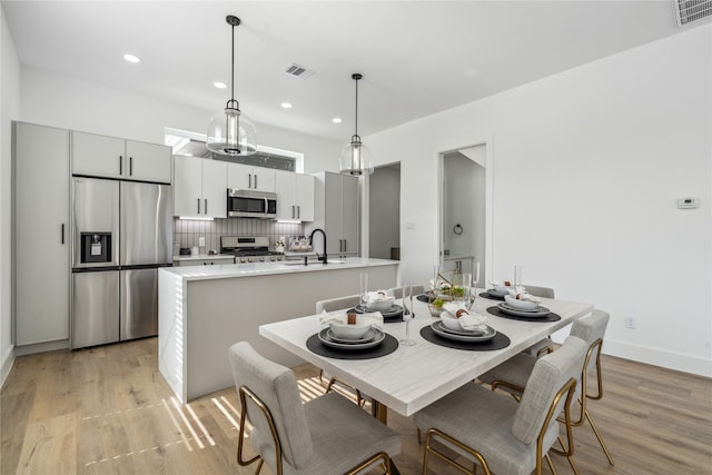 dining room with light hardwood / wood-style flooring and sink