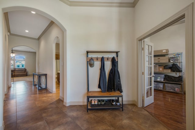 hallway featuring french doors, dark tile patterned flooring, and crown molding