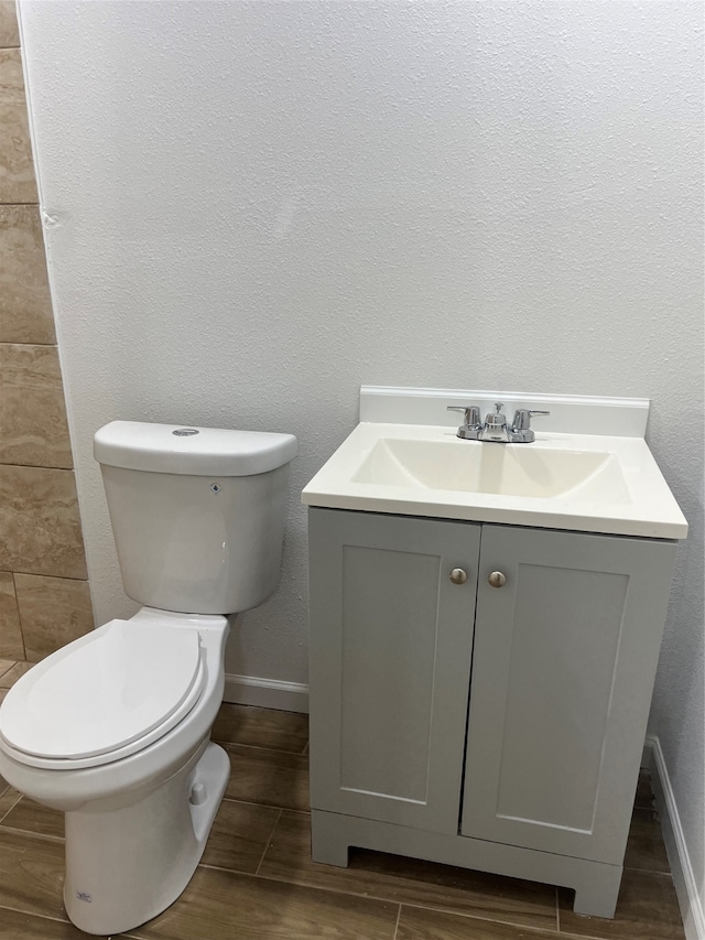 bathroom featuring wood-type flooring, vanity, and toilet