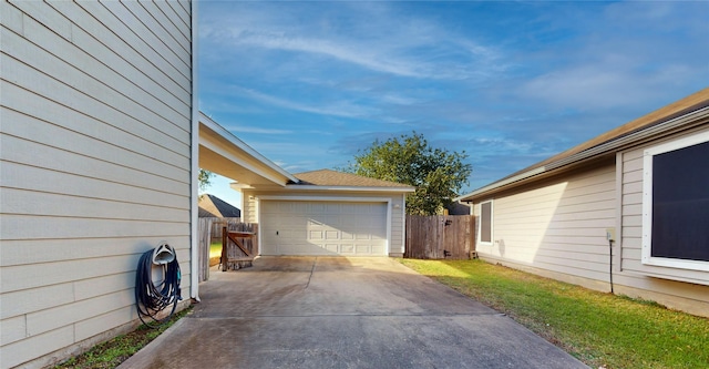 view of side of home featuring a detached garage and fence