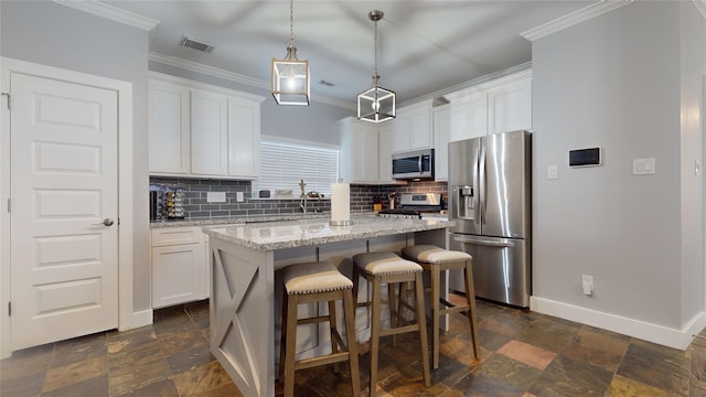 kitchen with stainless steel appliances, a kitchen island, visible vents, white cabinetry, and stone tile flooring