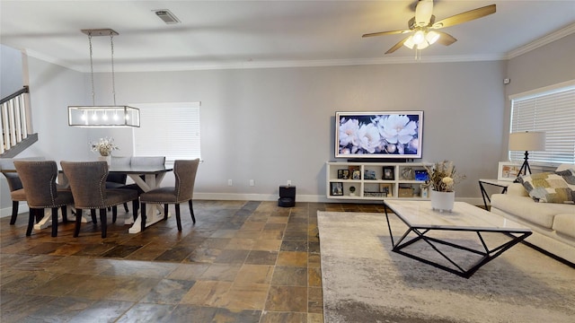 living area with visible vents, ornamental molding, a ceiling fan, stone finish floor, and baseboards