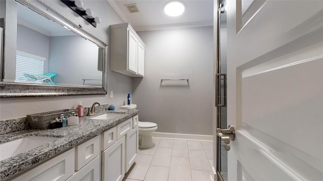 bathroom featuring toilet, a sink, visible vents, baseboards, and crown molding