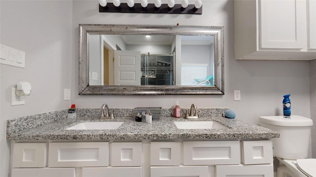 bathroom featuring a sink, toilet, and double vanity