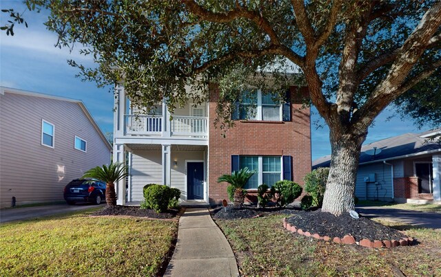 view of front of home with a front yard and a balcony