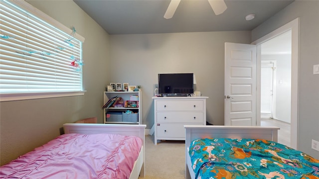 bedroom featuring light carpet and a ceiling fan