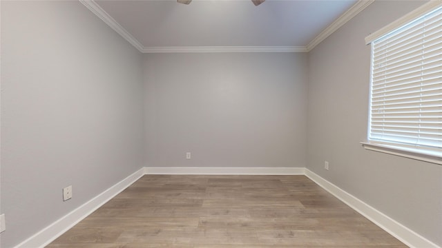 empty room with ornamental molding, baseboards, plenty of natural light, and light wood finished floors