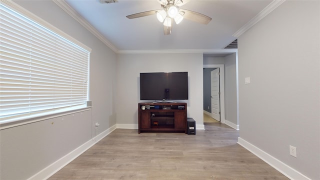 unfurnished living room featuring light wood finished floors, visible vents, ornamental molding, a ceiling fan, and baseboards