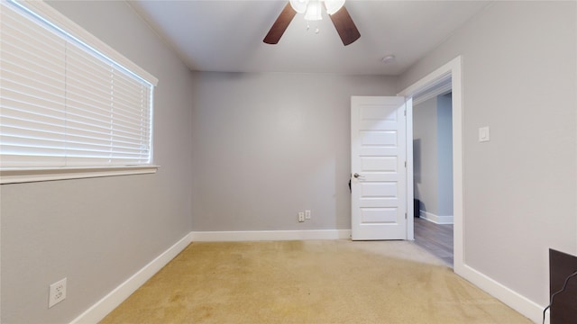 unfurnished room with light carpet, ceiling fan, and baseboards