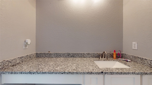 bathroom featuring a textured wall and vanity