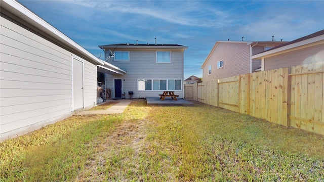 back of property featuring a fenced backyard, a lawn, and a patio