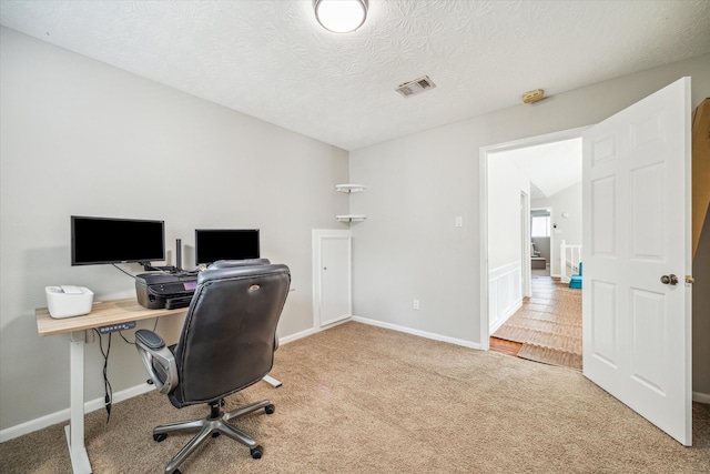 home office with carpet floors and a textured ceiling