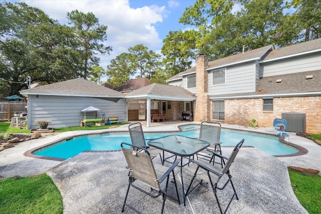 view of swimming pool with a patio and central air condition unit