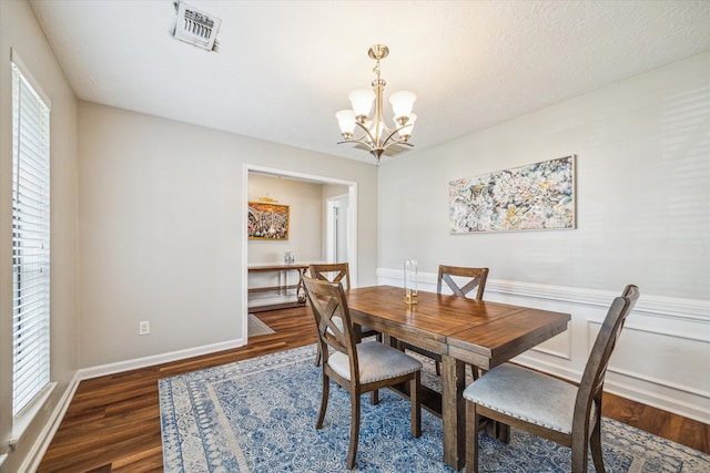 dining space featuring a notable chandelier and dark hardwood / wood-style floors