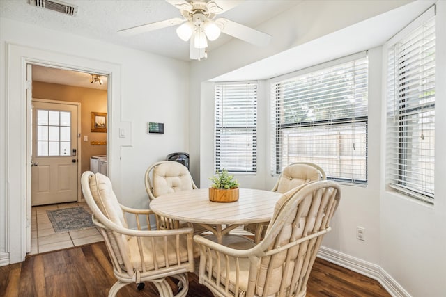 dining space featuring dark wood-type flooring, ceiling fan, and washer and clothes dryer