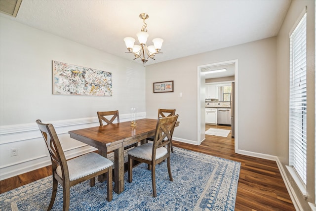 dining room with dark hardwood / wood-style flooring and a notable chandelier