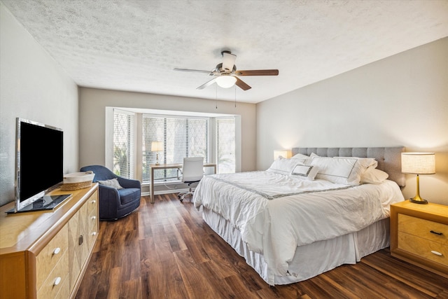 bedroom featuring dark wood-type flooring, ceiling fan, and a textured ceiling