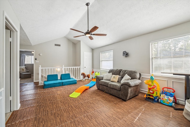 playroom featuring vaulted ceiling and a textured ceiling