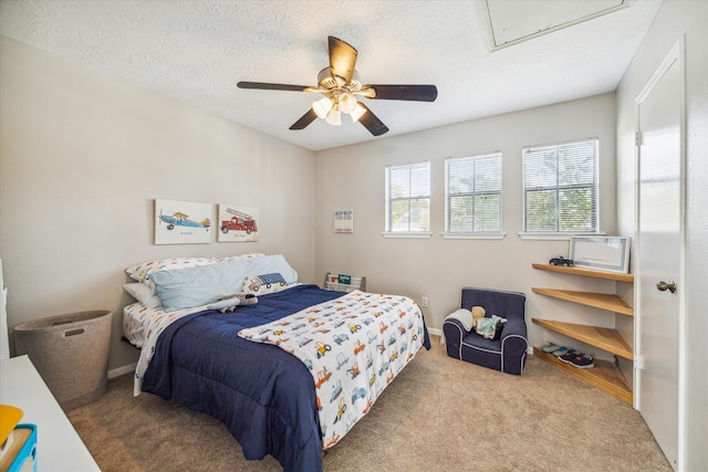 carpeted bedroom featuring a textured ceiling and ceiling fan