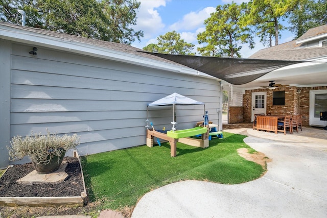 view of yard with ceiling fan and a patio