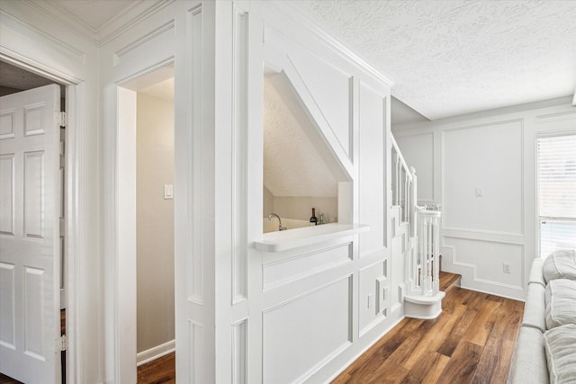 bathroom with crown molding, hardwood / wood-style flooring, and a textured ceiling