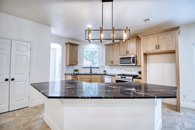 kitchen featuring sink, a center island, pendant lighting, and appliances with stainless steel finishes