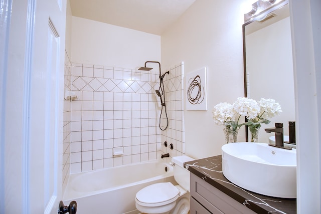 full bathroom with vanity, tiled shower / bath combo, and toilet