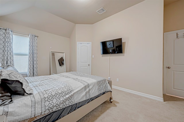 bedroom with light colored carpet and vaulted ceiling