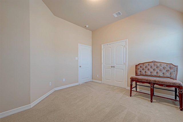 living area featuring light colored carpet and vaulted ceiling