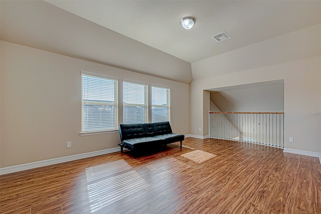 unfurnished room with hardwood / wood-style floors and lofted ceiling