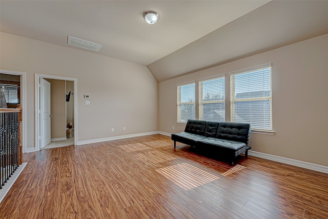 unfurnished room featuring light hardwood / wood-style flooring and lofted ceiling