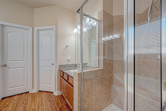 bathroom featuring vanity, hardwood / wood-style flooring, and a shower with shower door