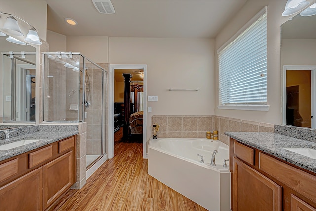 bathroom with shower with separate bathtub, vanity, ceiling fan, and wood-type flooring