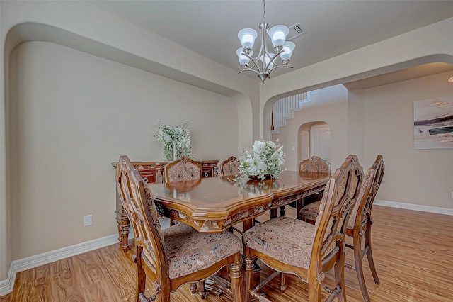 dining space with a chandelier and light hardwood / wood-style floors