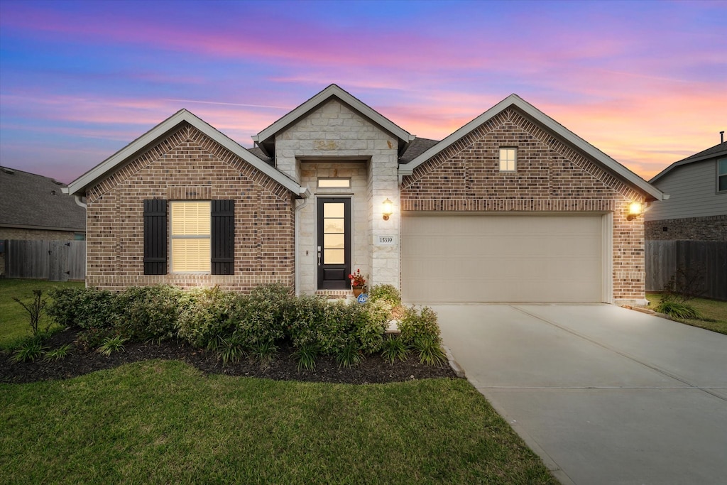 view of front of property featuring a garage and a yard