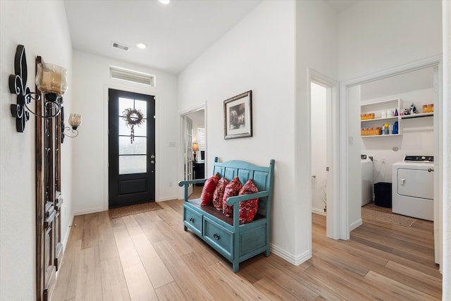 entryway with washing machine and clothes dryer and light wood-type flooring