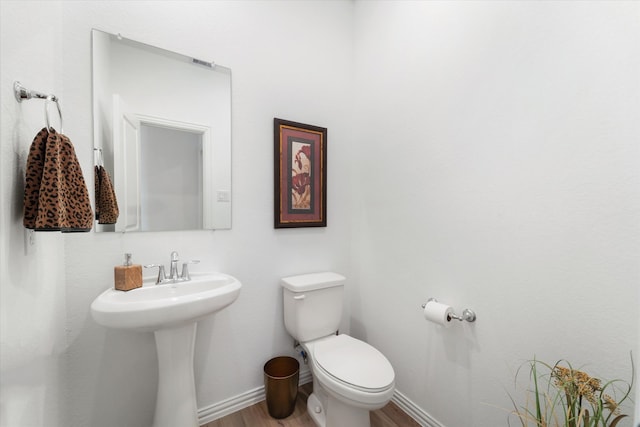 bathroom featuring toilet and wood-type flooring