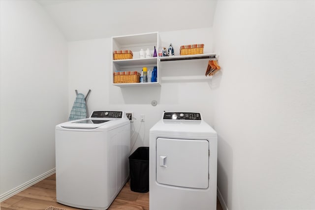 laundry room with washer and dryer and light wood-type flooring