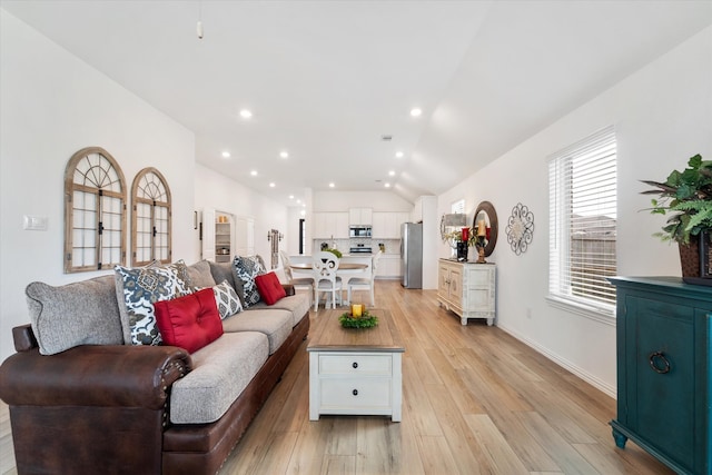 living room featuring light hardwood / wood-style flooring and vaulted ceiling